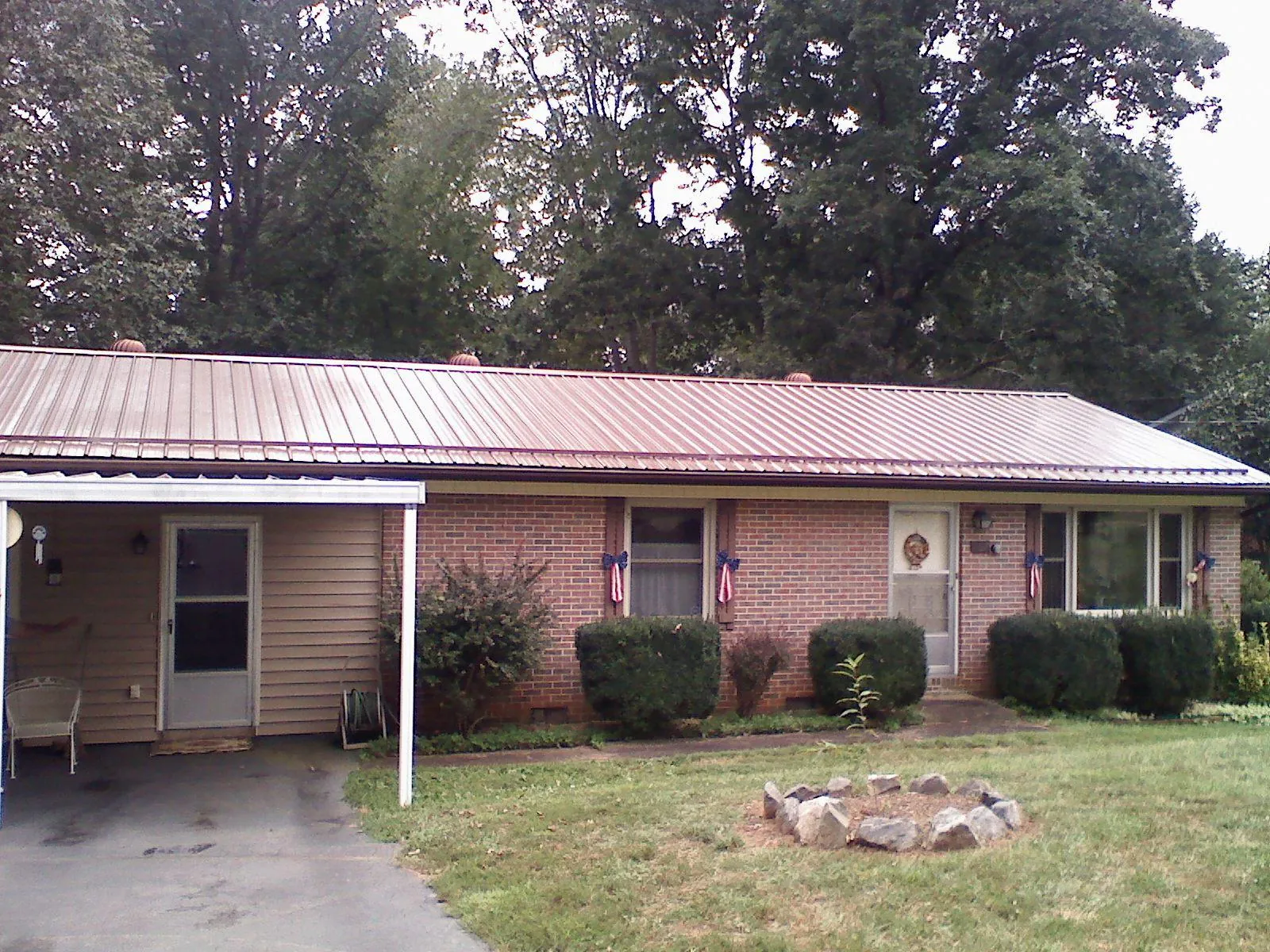 Bronze metal roof and carport on a brick ranch home — Roof Repair work by our crew in Poolville